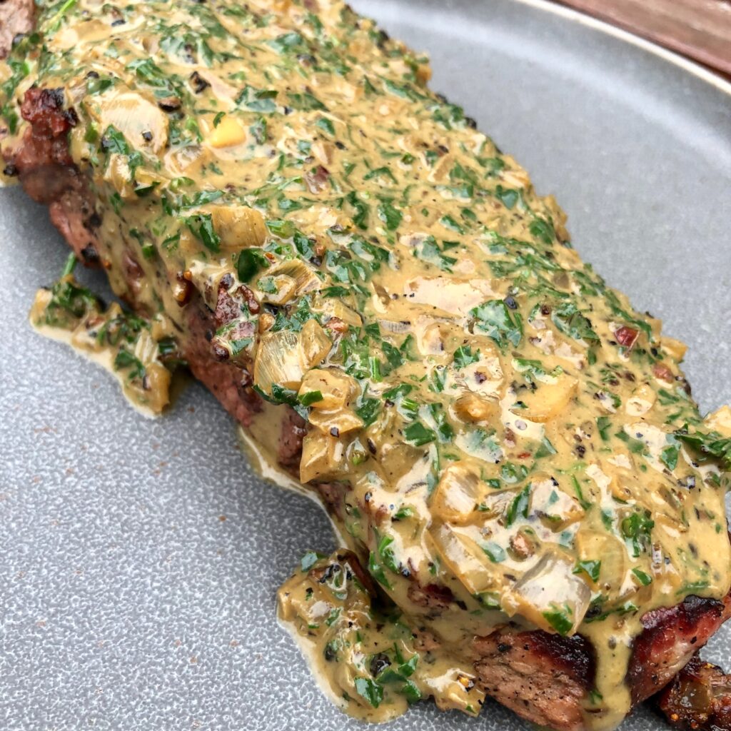 Pepper crusted steak on plate.