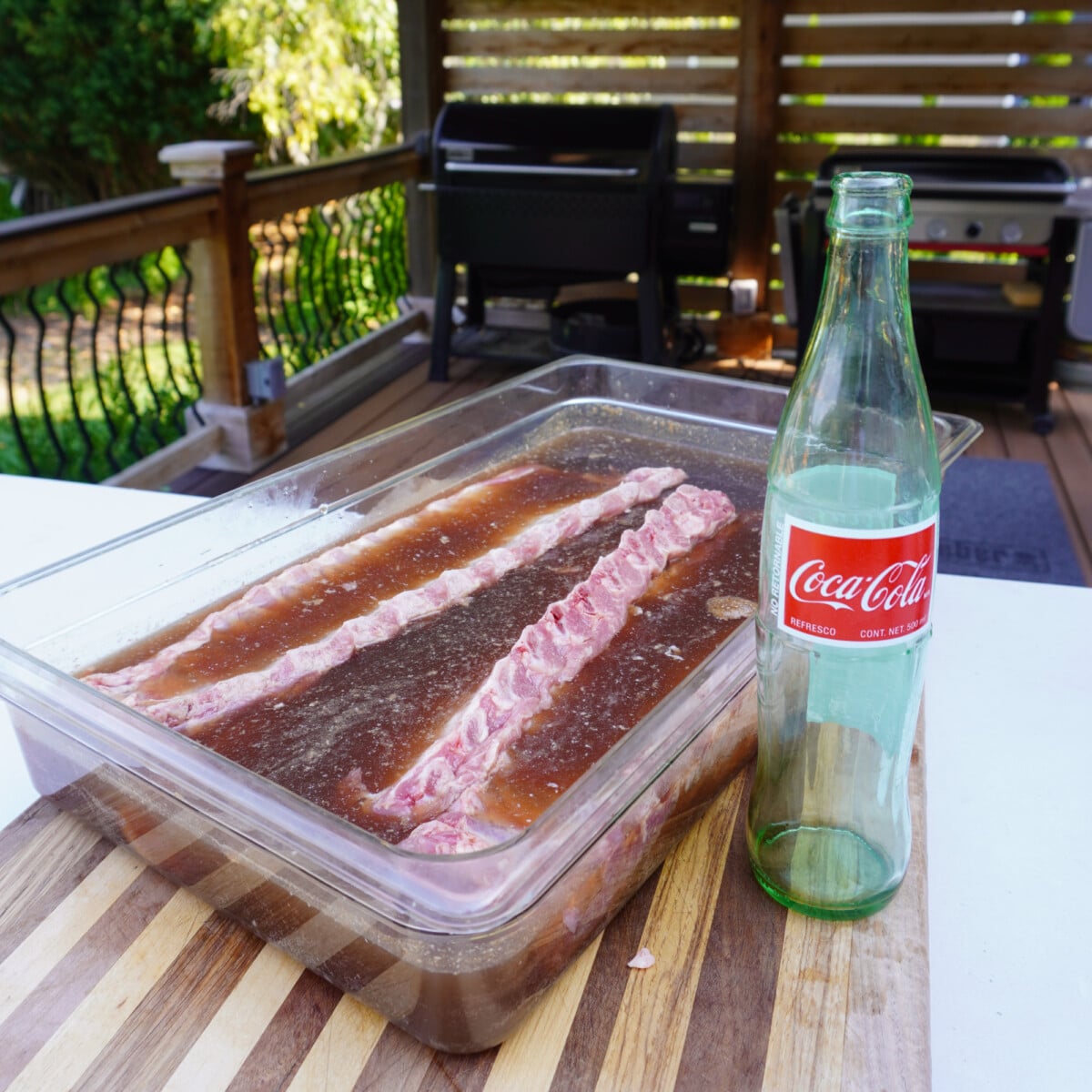 raw baby back ribs marinating in a coca-cola bath.