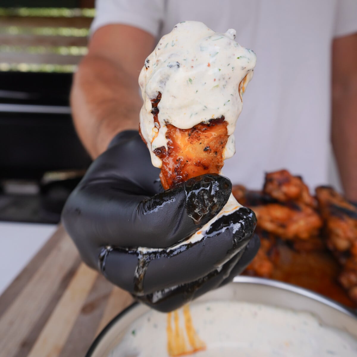 Grilled chicken wing dunked in the ranch dressing.