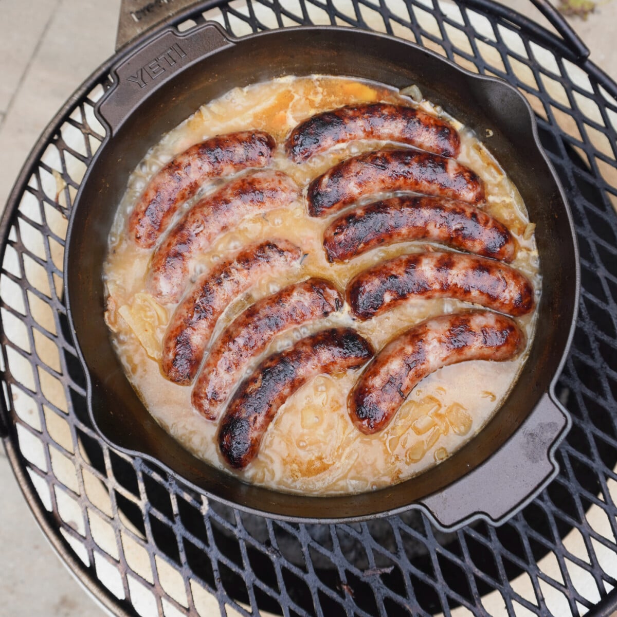 the best grilled beer brats in a dutch oven over a fire.