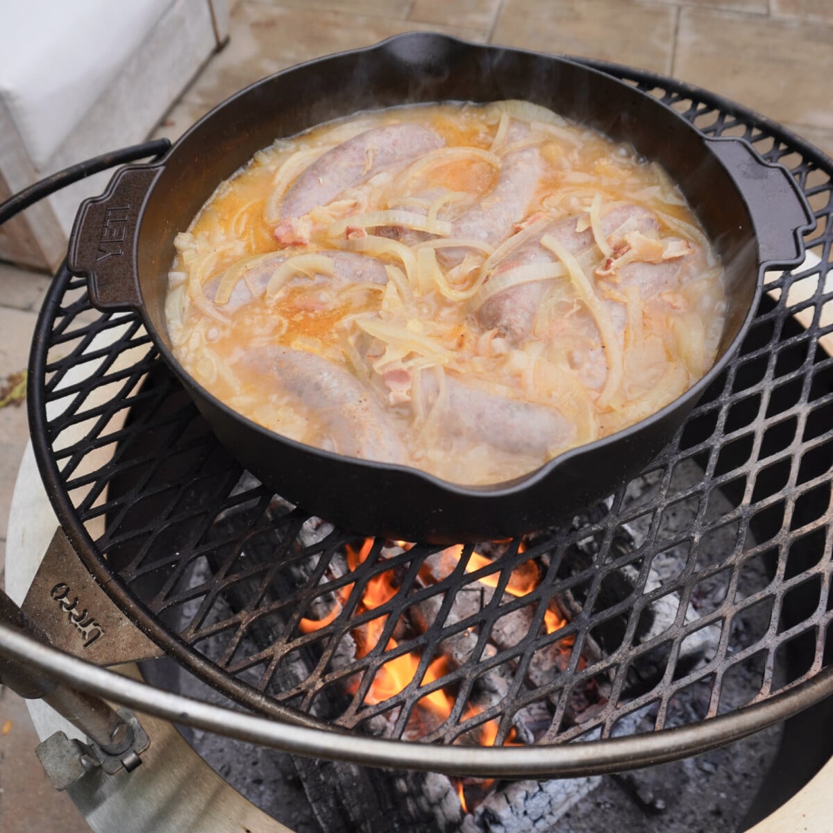 grilling the beer and brats over fire on a breeo grill.
