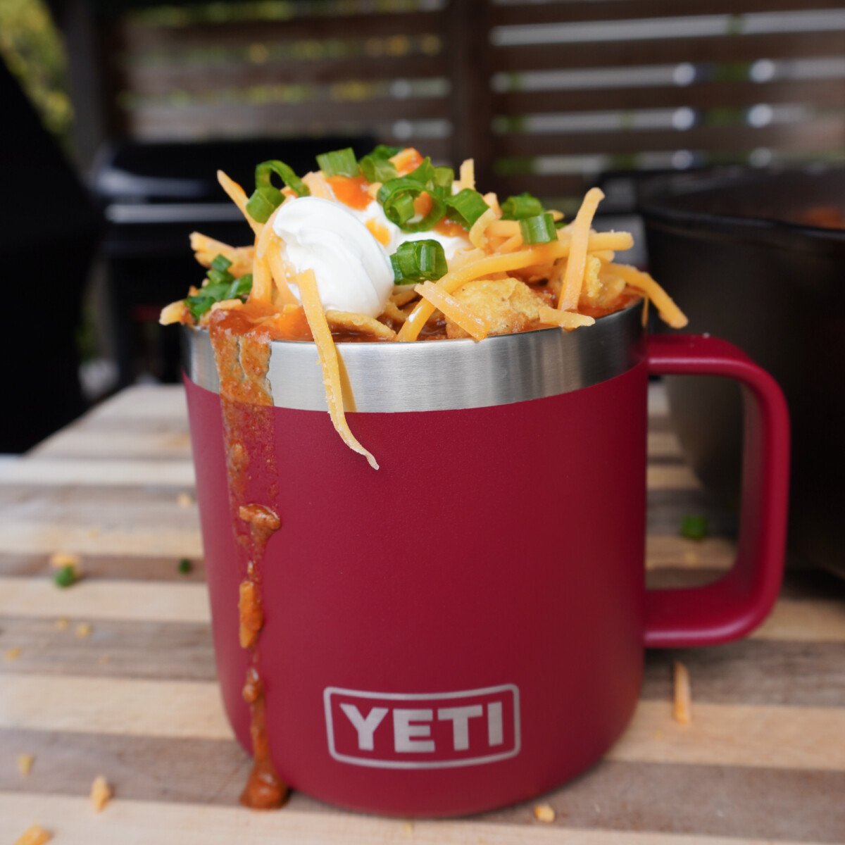 Over the top chili in a red up loaded with toppings.