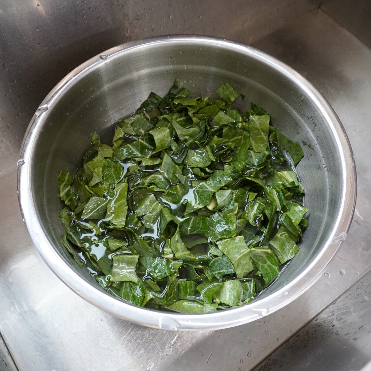 cleaned collard greens in a bowl with water.