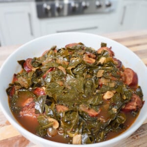Collard Greens and Sausage plated in a white bowl.