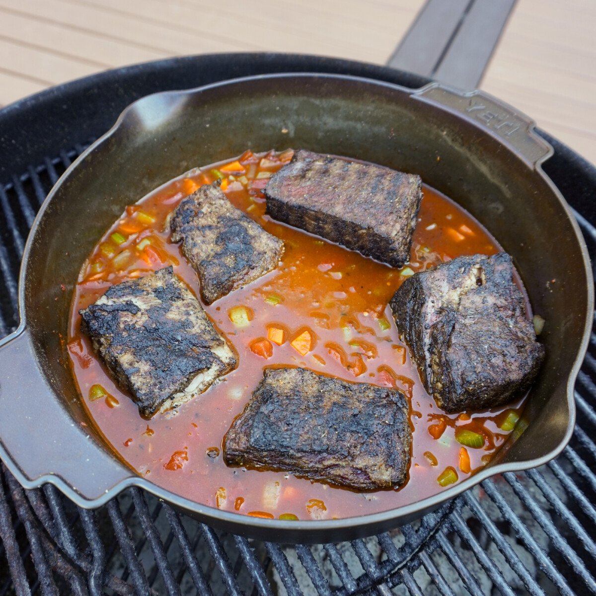 Ragu broth and grilled short ribs in cast iron skillet.