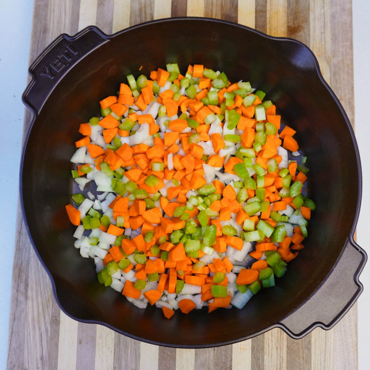 Diced veggies in deep cast iron skillet.
