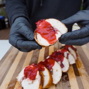 Cranberry Stuffed Turkey Breast slice held in hands.