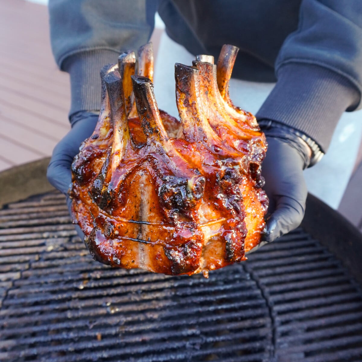 holiday crown roast presented over a grill.
