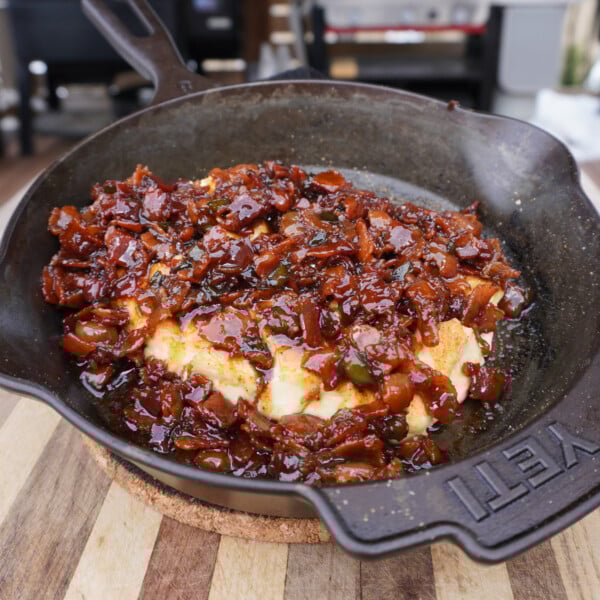 smoked cream cheese with bacon jam in a cast iron skillet.