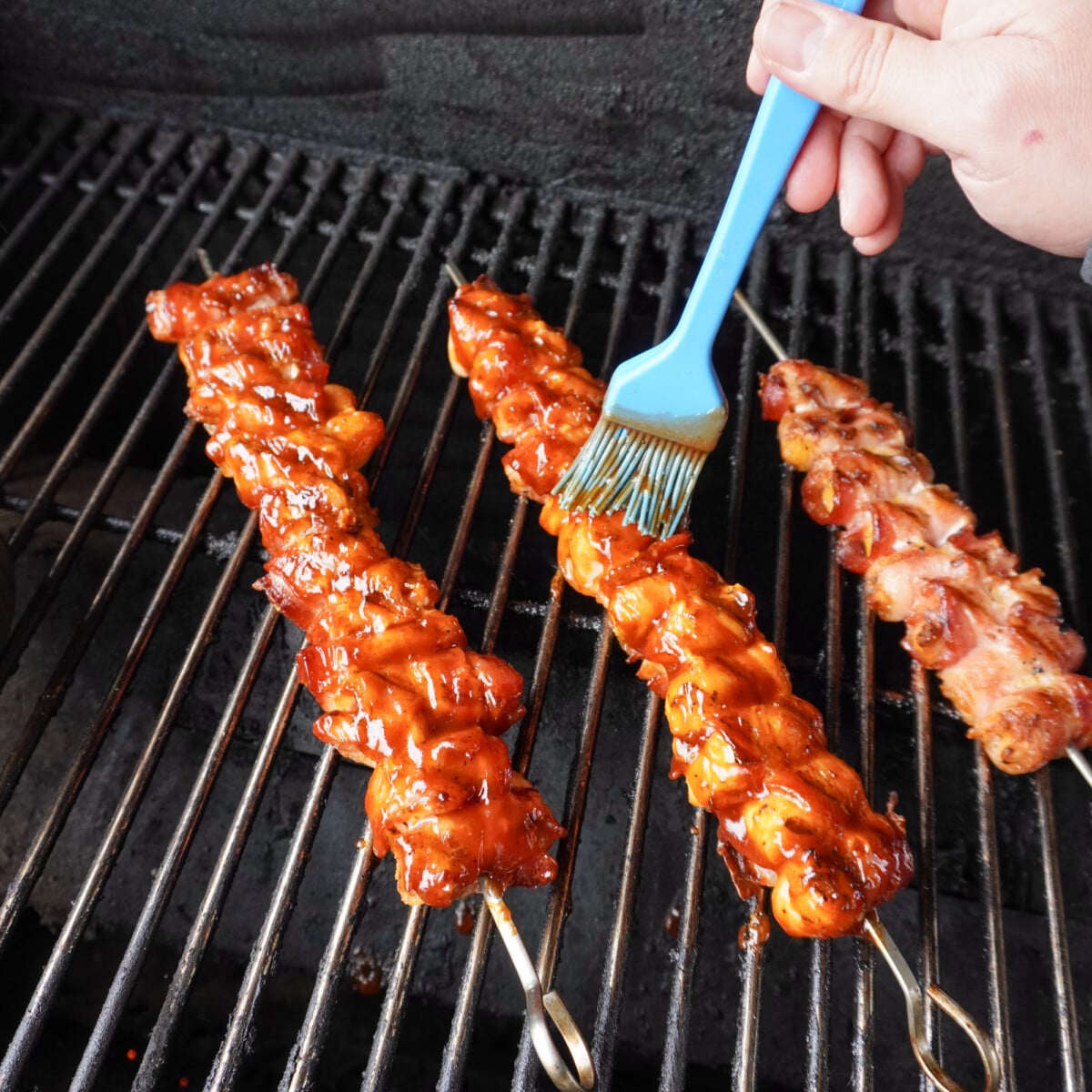 brushing BBQ sauce over BBQ food.