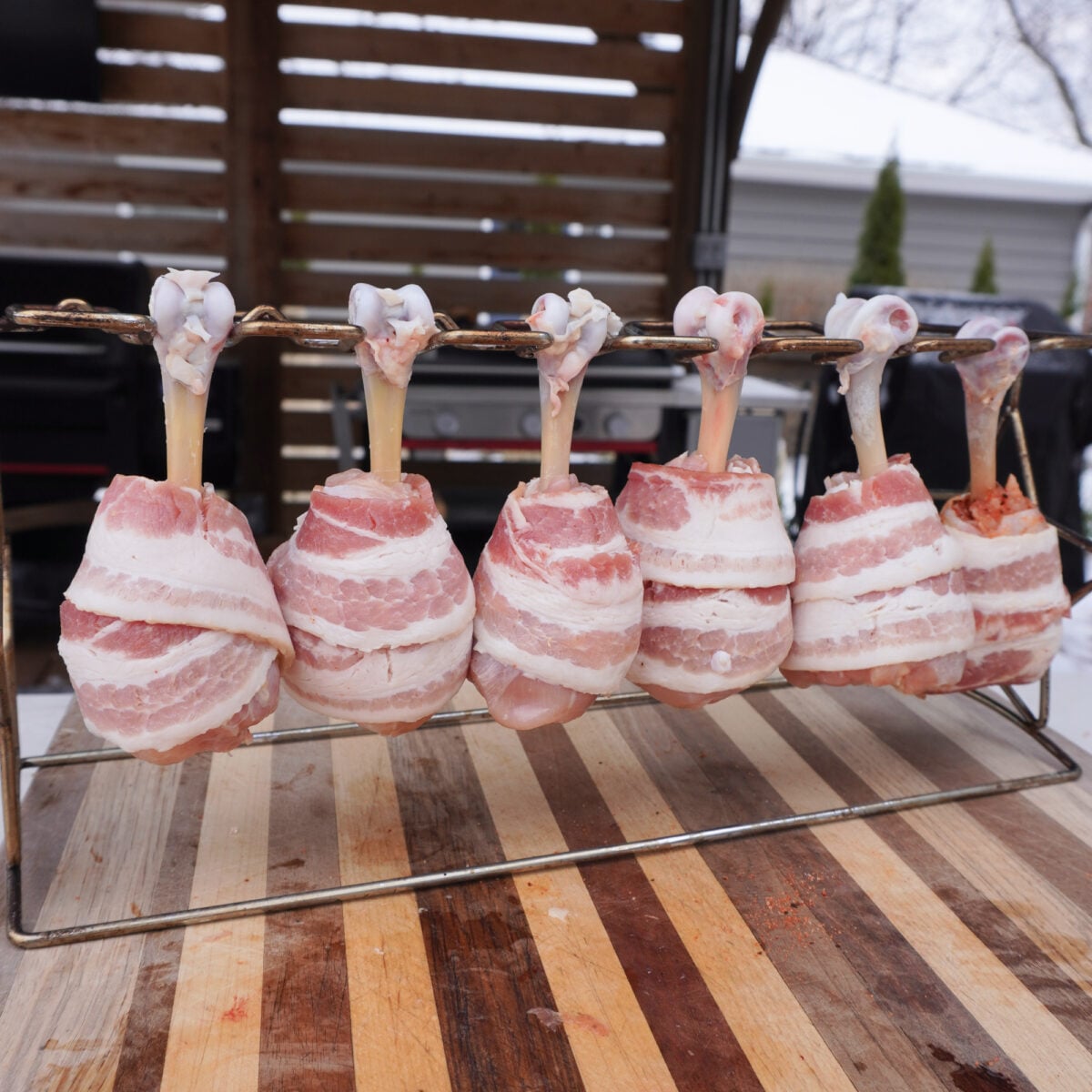 Bacon Wrapped Chicken Drumsticks on a wire rack.