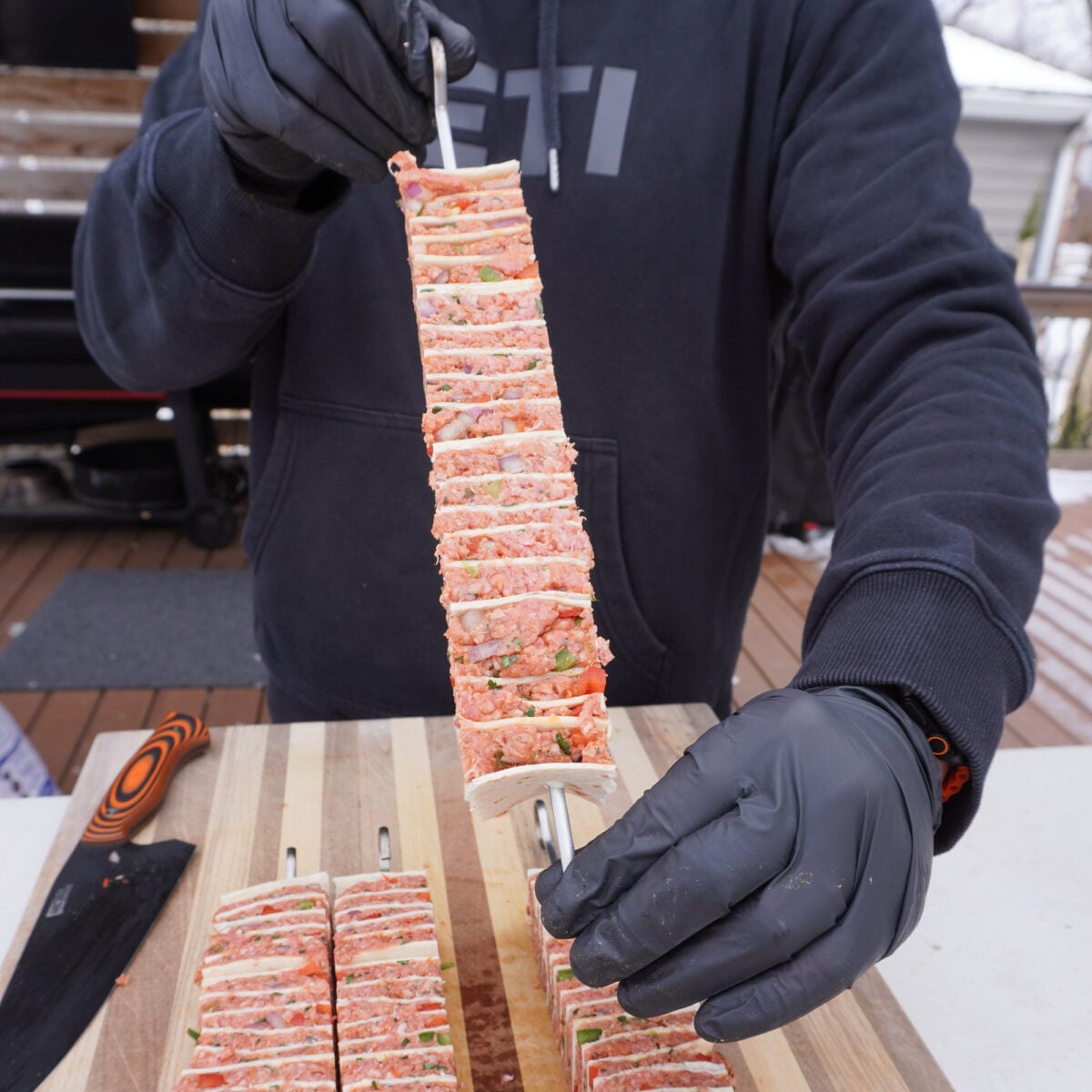 raw tortilla beef kebab on a metal skewer.