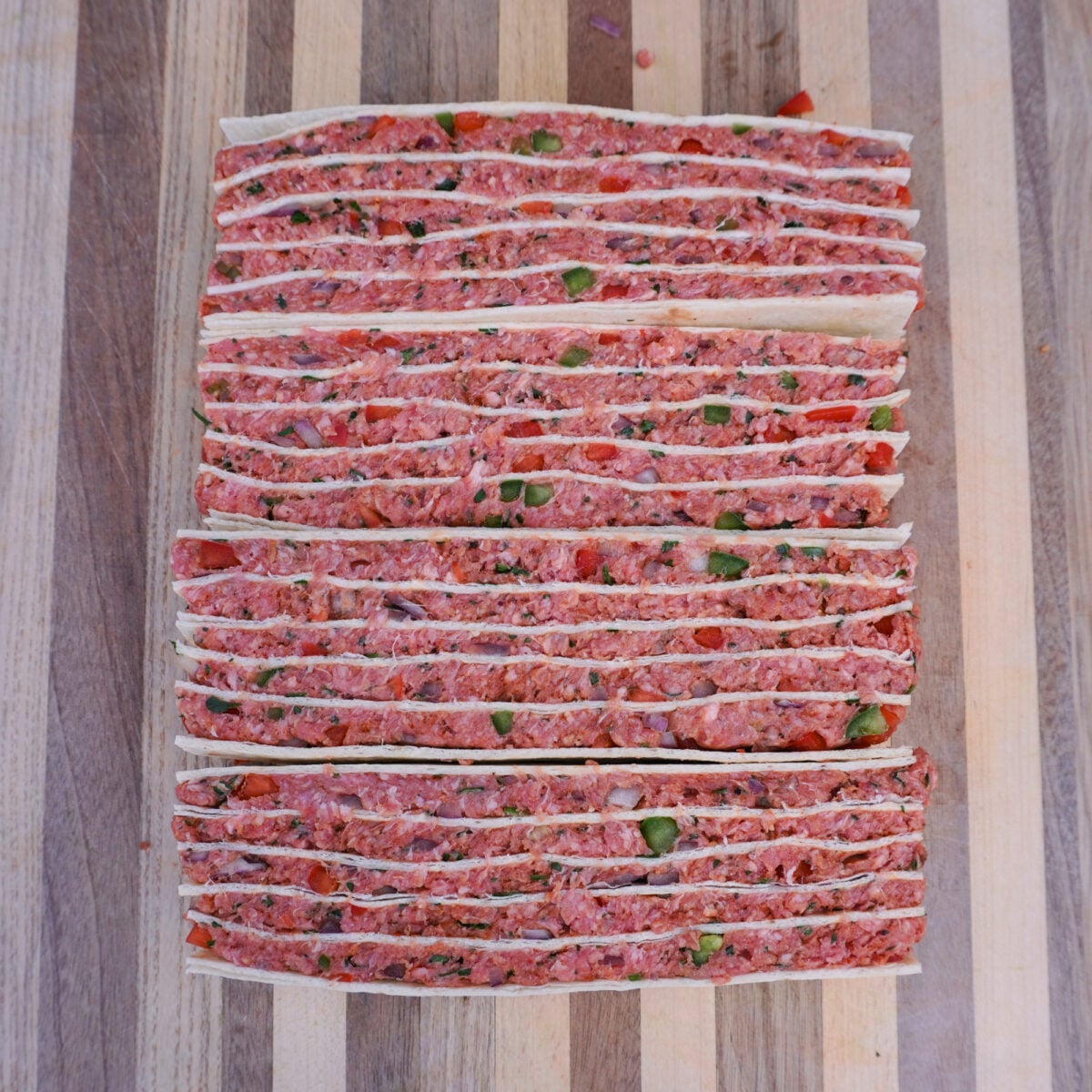 Even layers of tortillas and beef mix stacked.