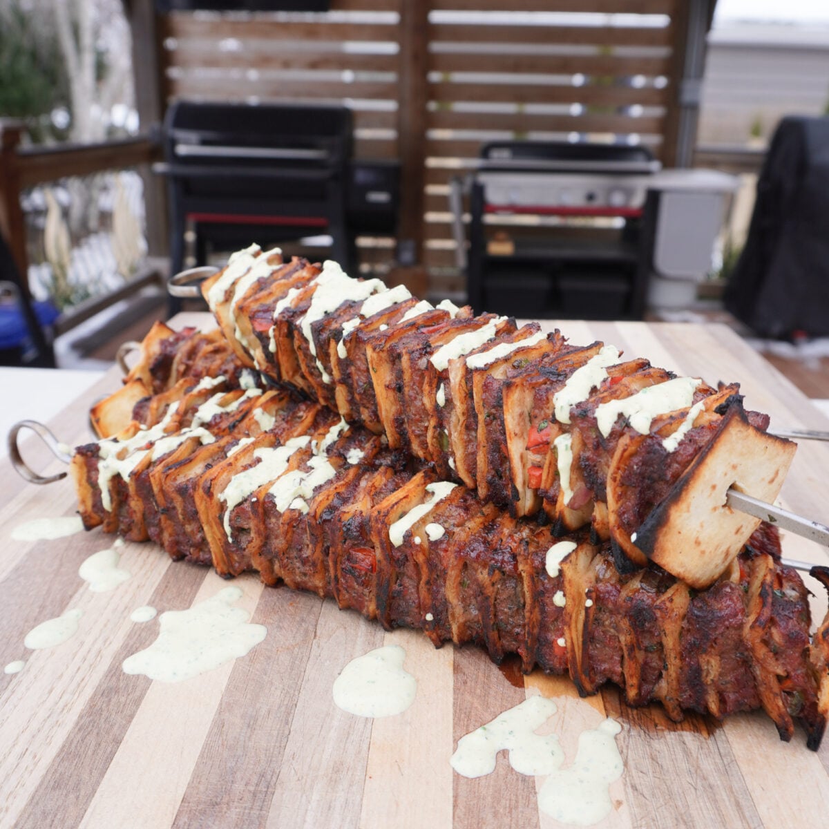 Grilled Tortilla Beef Kebob on a cutting board with a spicy cilantro sauce drizzle.