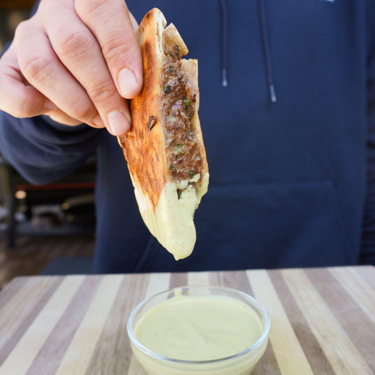 Grilled Beef Arayes dipped in a creamy avocado and cilantro sauce.