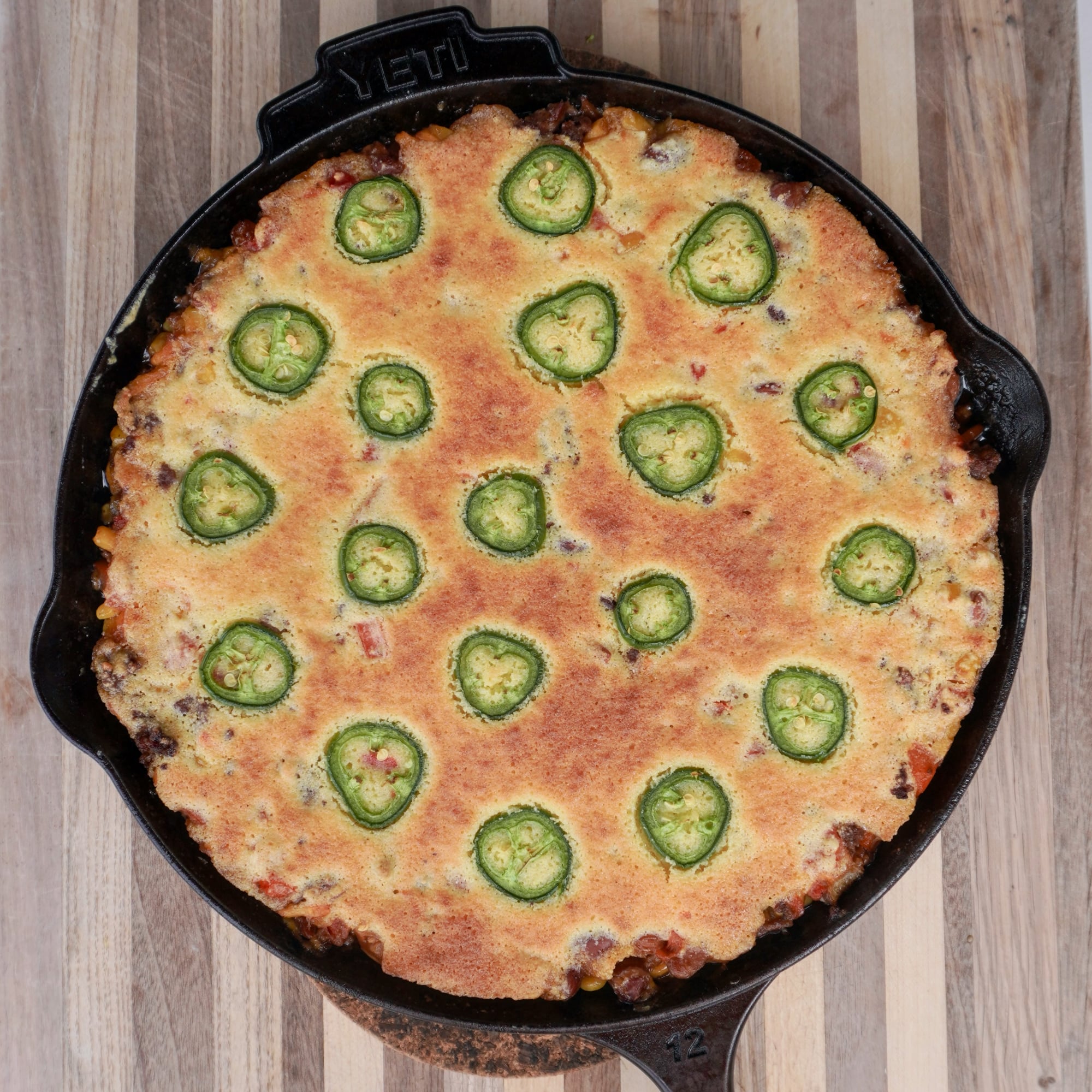 grilled cornbread cowboy casserole resting on cutting board.