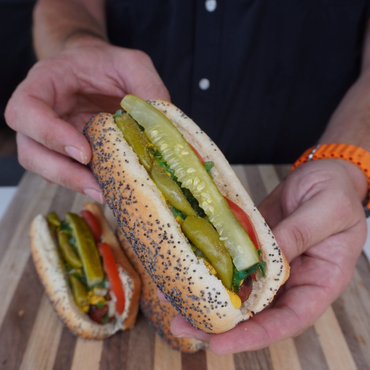 hands presenting the a chicago style hotdog.
