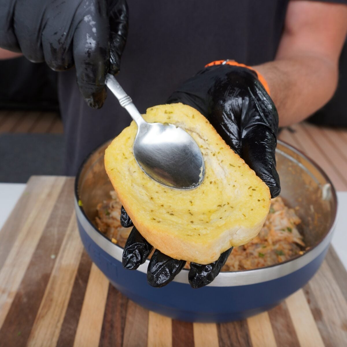 pressing into the toast to create a crater for the seafood stuffing.