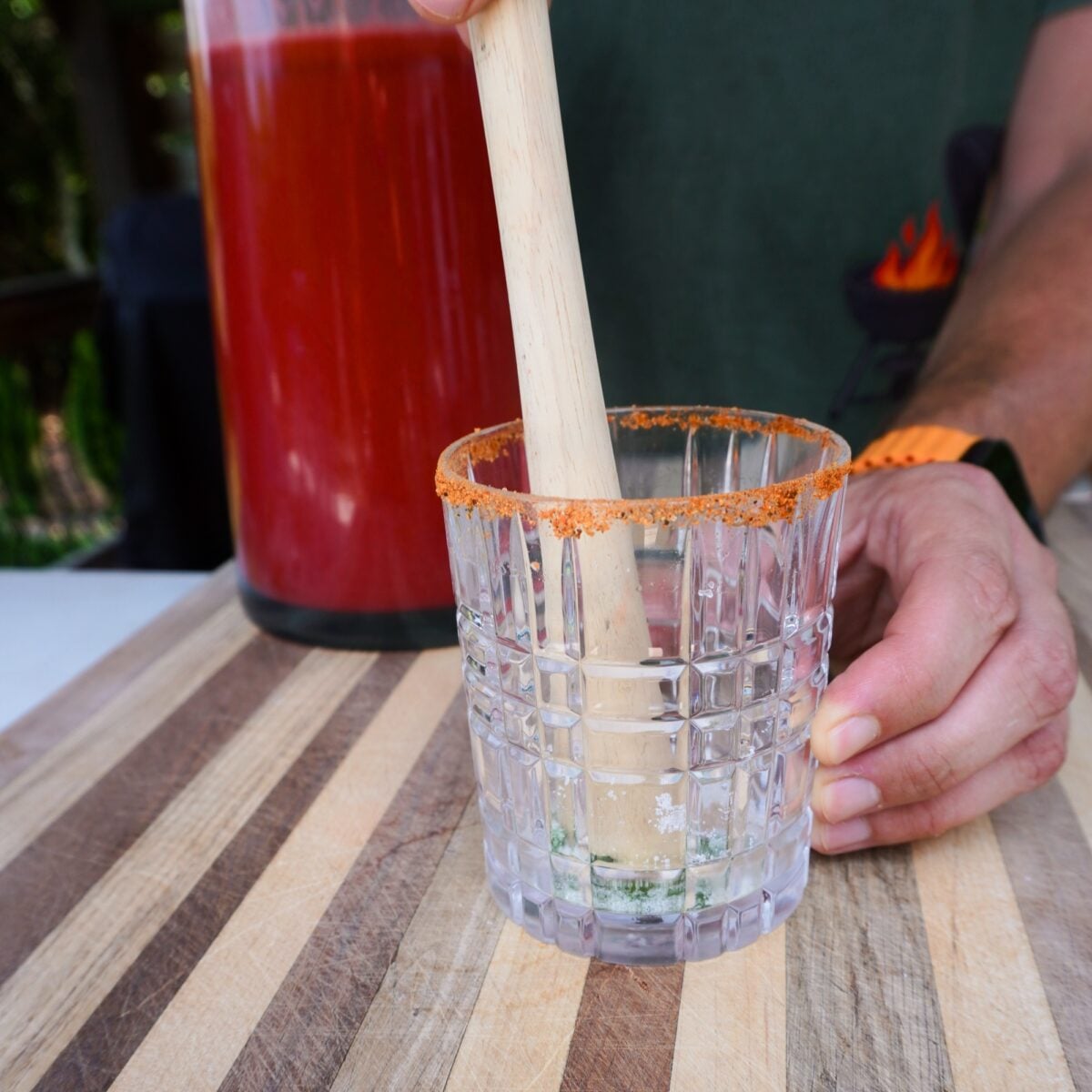 Muddling sugar and mint in glass.