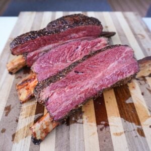 Sliced Smoked Pastrami Beef Ribs on a cutting board.