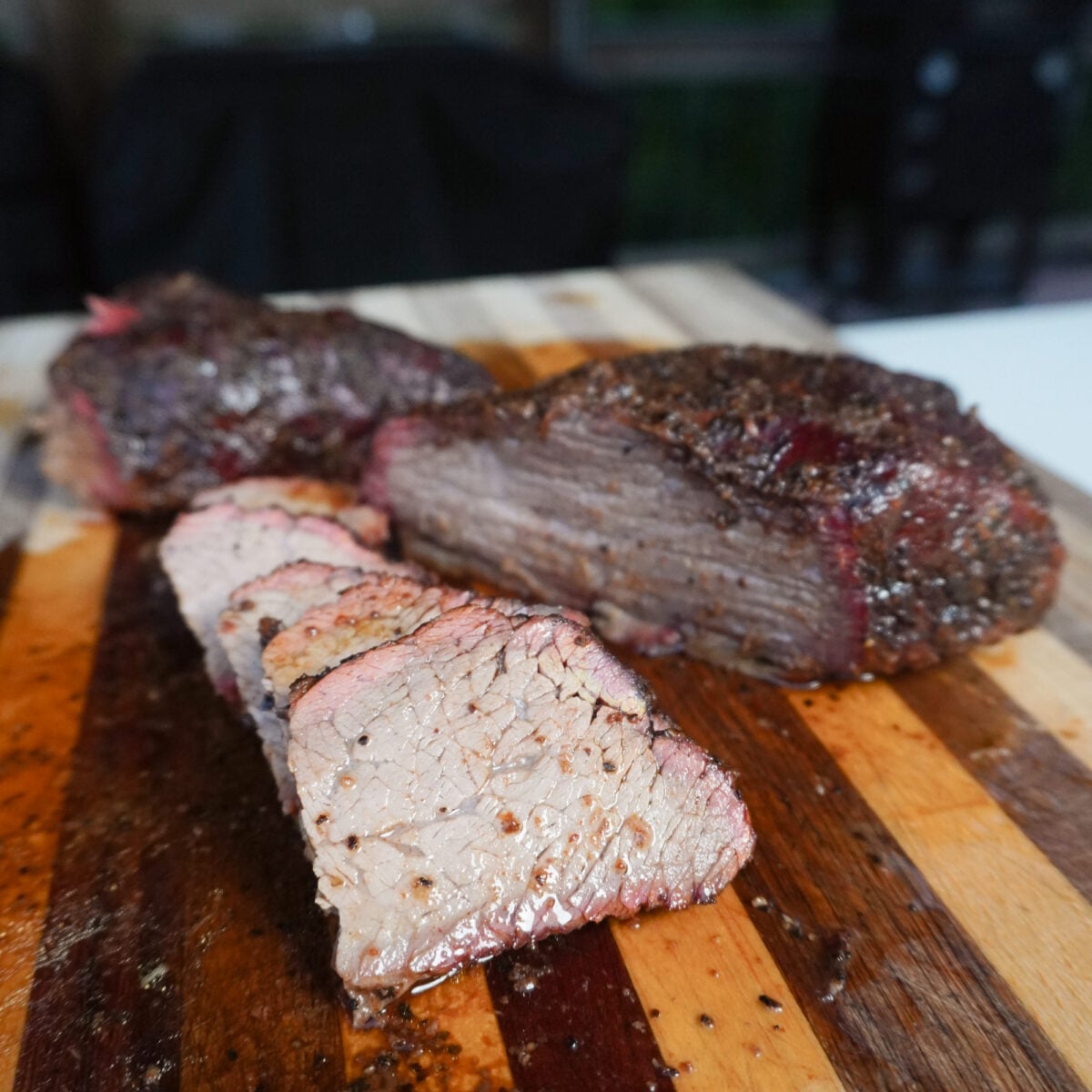 sliced brisket style smoked tri tip on cutting board.
