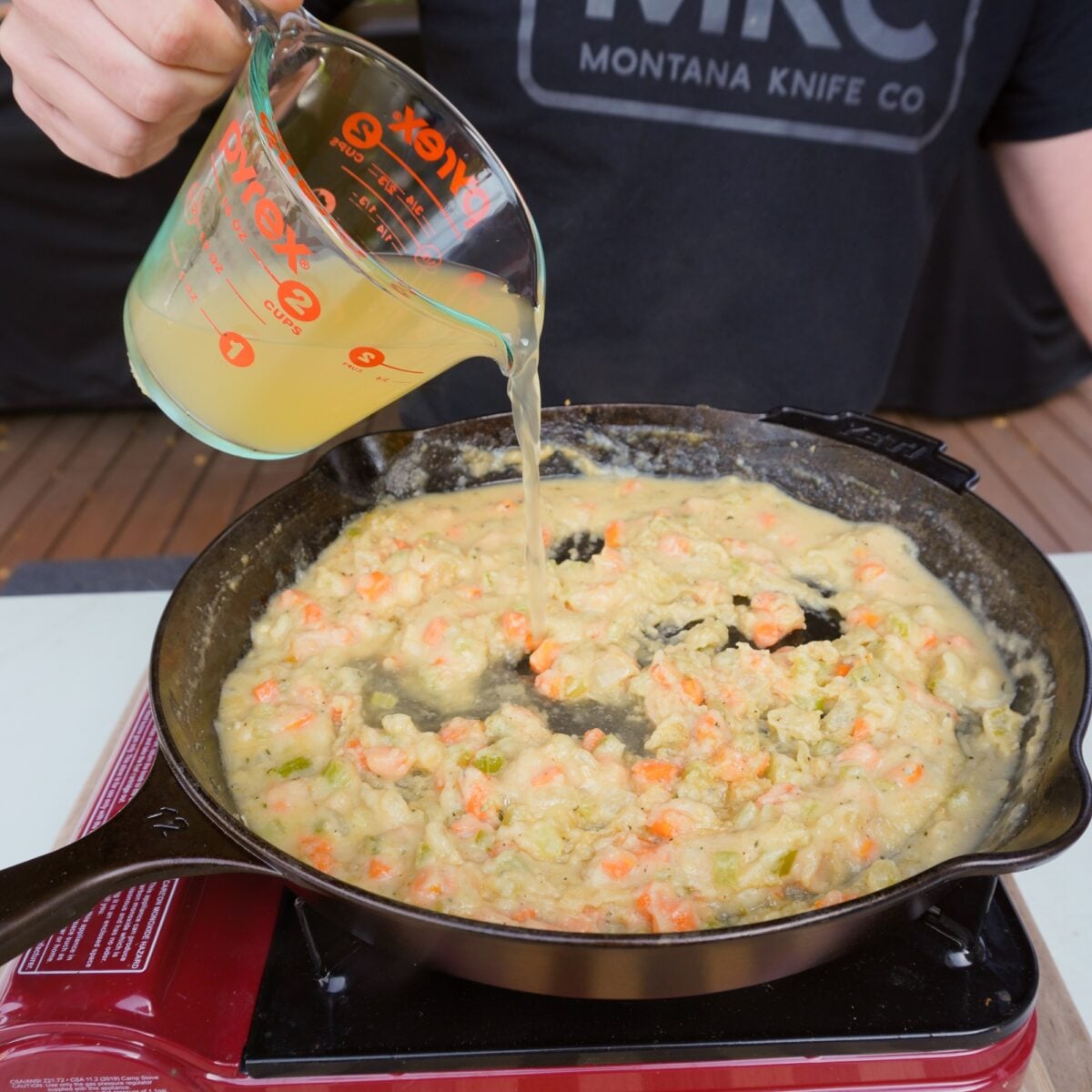 Adding in chicken broth to Smoked Chicken Pot Pie filling.
