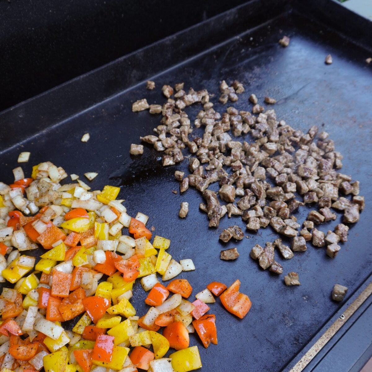 steak and veggies on the griddle.