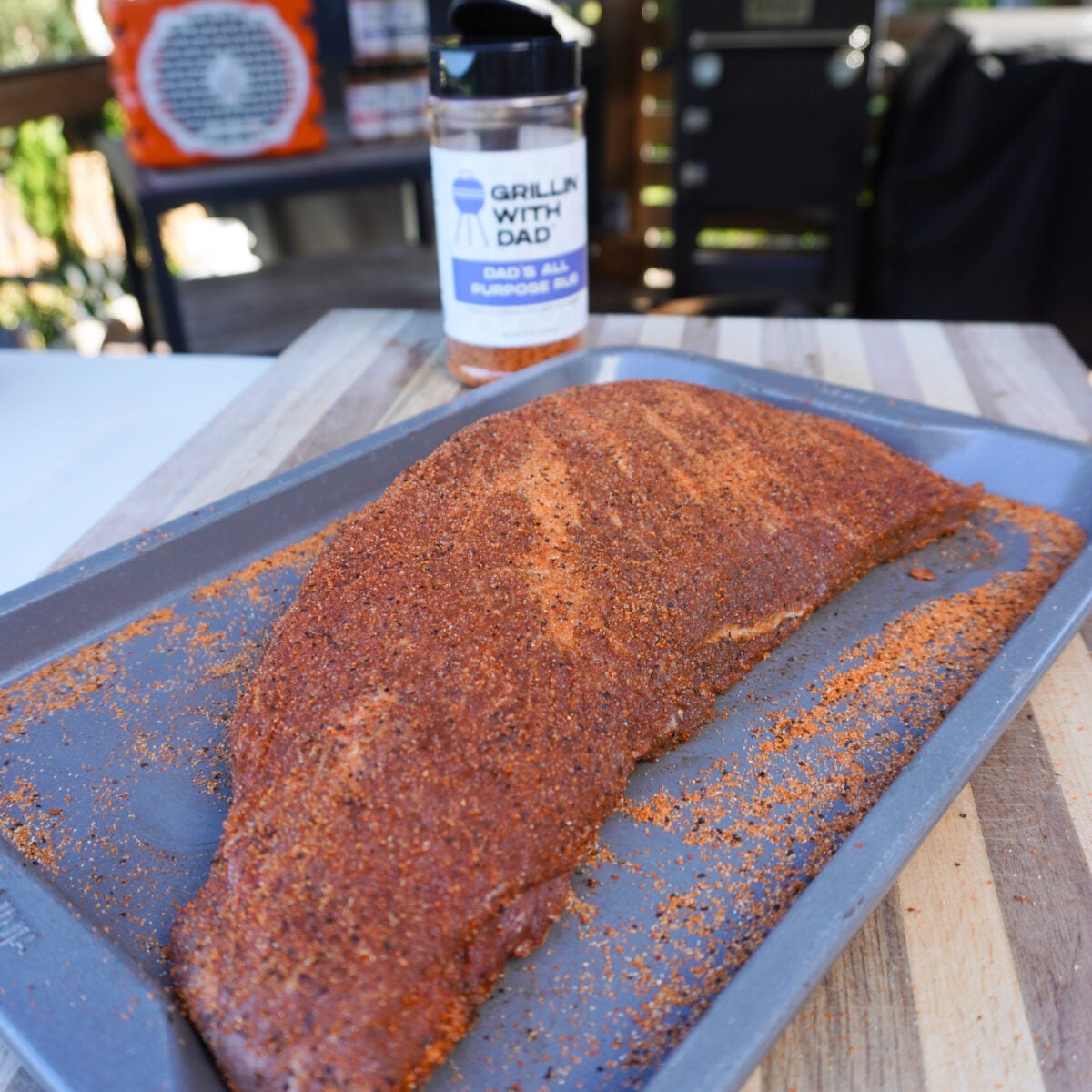 Seasoned tri-tip steak on a sheet pan.